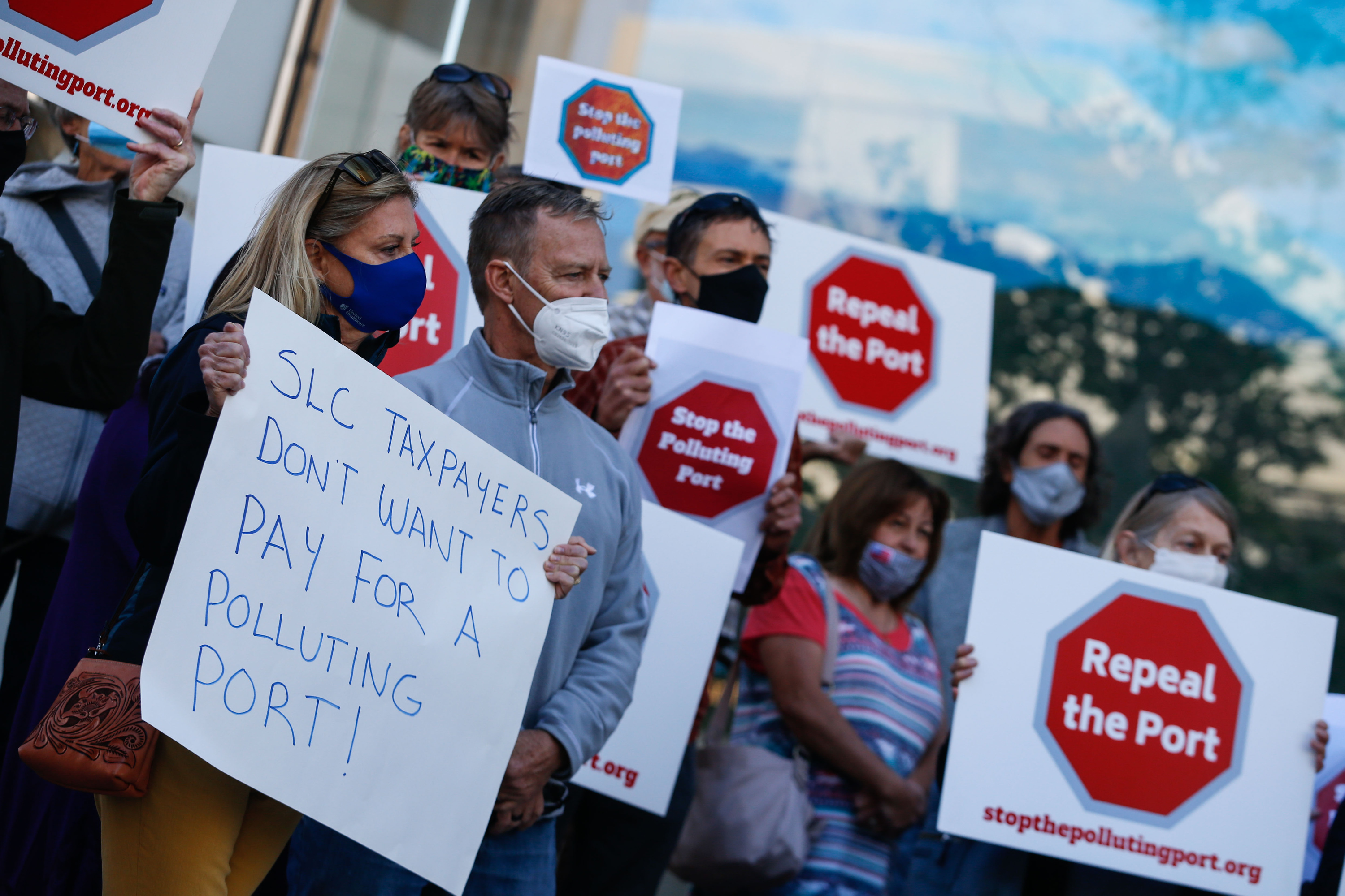 Members of Stop the Polluting Port Coalition holds signs outside the offices of the Utah Inland Port Authority in Salt Lake City on Monday, Sept. 20, 2021, protesting the port authority’s planned vote to adopt a public infrastructure district.