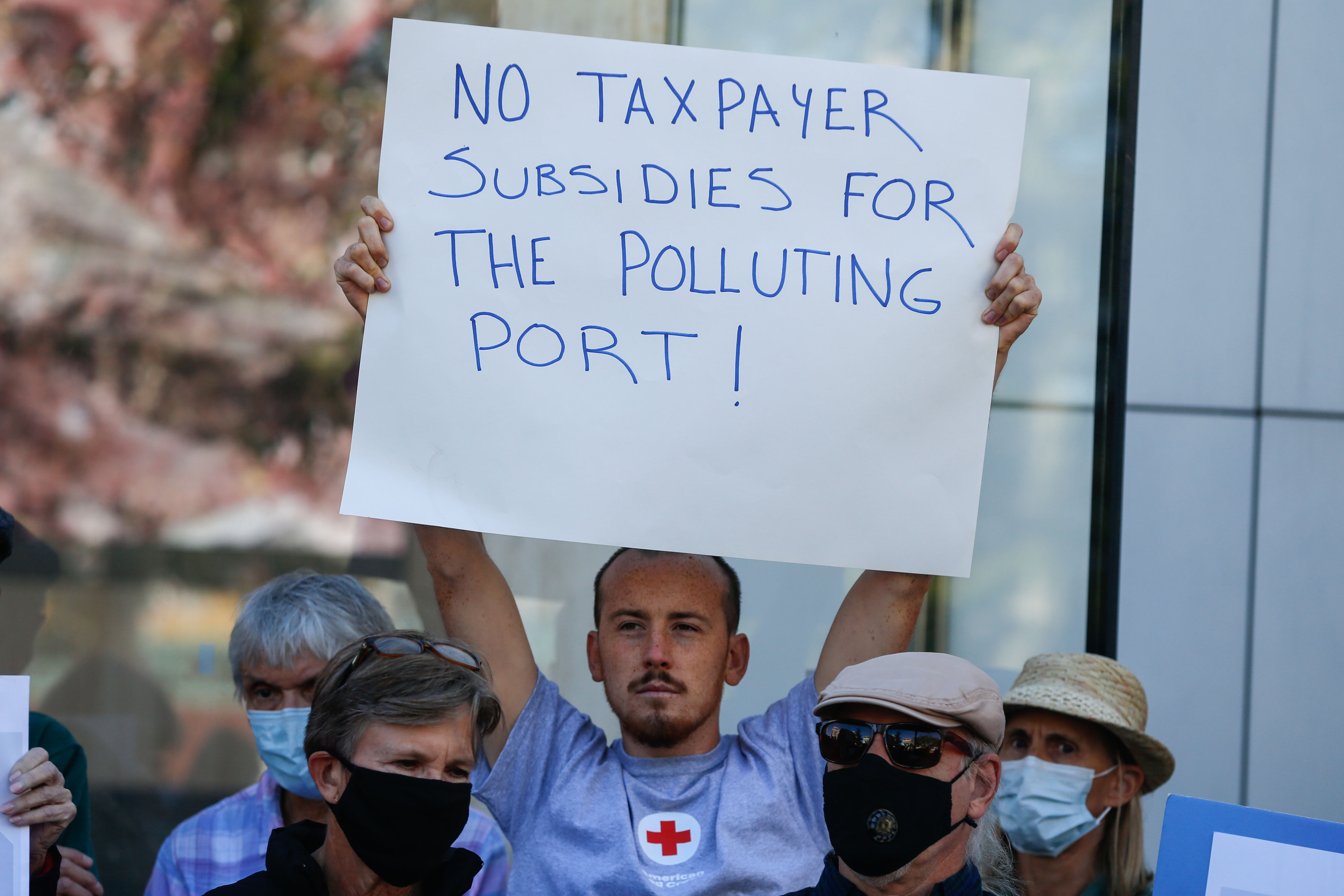 Members of Stop the Polluting Port Coalition holds signs outside the offices of the Utah Inland Port Authority in Salt Lake City on Monday, Sept. 20, 2021, protesting the port authority’s planned vote to adopt a public infrastructure district.