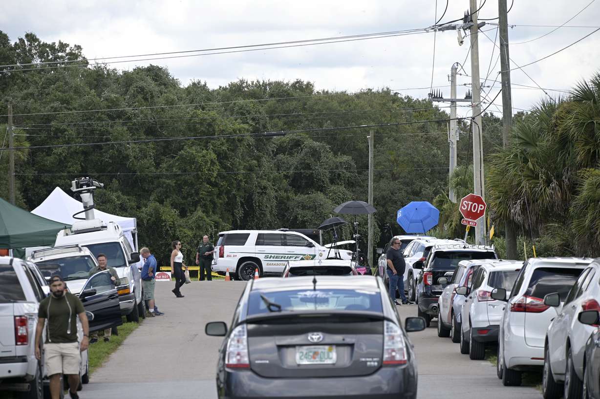 Vehicles from members of the media and curious passersby line a road outside the entrance of the Carlton Reserve during a search for Brian Laundrie, Tuesday.