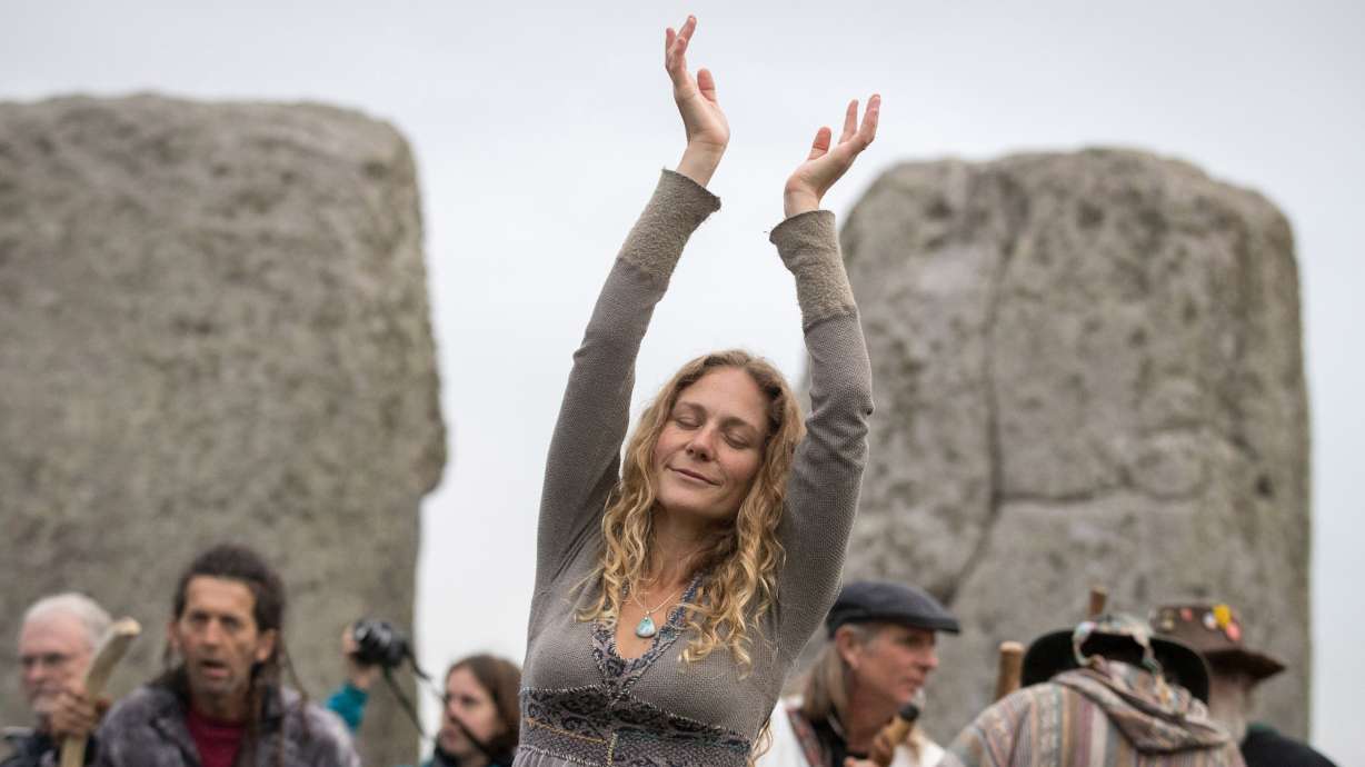 A woman dances as druids, pagans, and revelers gather at Stonehenge, hoping to see the sunrise, as they take part in an autumn equinox celebration on Sept. 23, 2017, in Wiltshire, England.