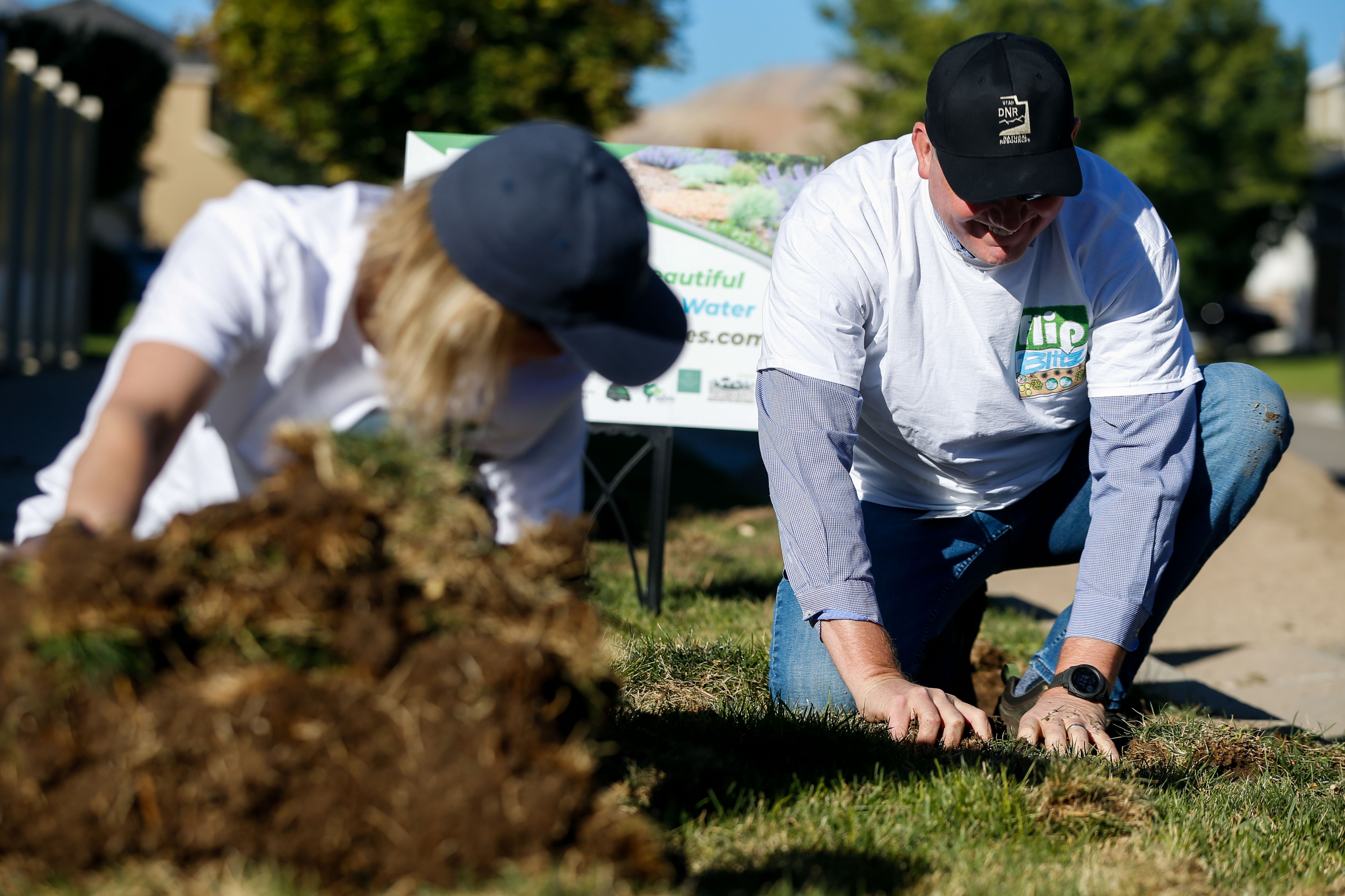 Candice Hasenyager and Brian Steed remove sod from a parking strip in Herriman on Sept. 21, 2021. A proposed bill would limit the use of "nonfunctional turf" for new government construction within the Great Salt Lake Basin.