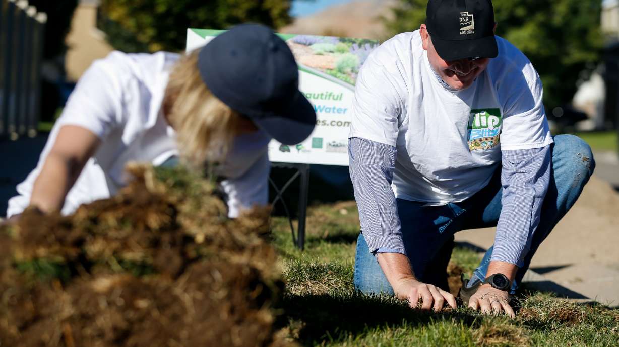 Candice Hasenyager and Brian Steed remove sod from a parking strip in Herriman on Sept. 21, 2021. A proposed bill would limit the use of "nonfunctional turf" for new government construction within the Great Salt Lake Basin.