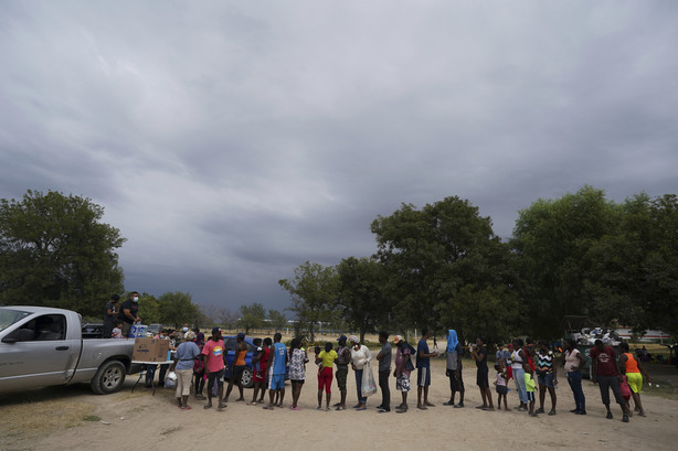 Migrants from Haiti line up to receive clothes from Mexican volunteers at an improvised refugee shelter in Ciudad Acuña, Tuesday.