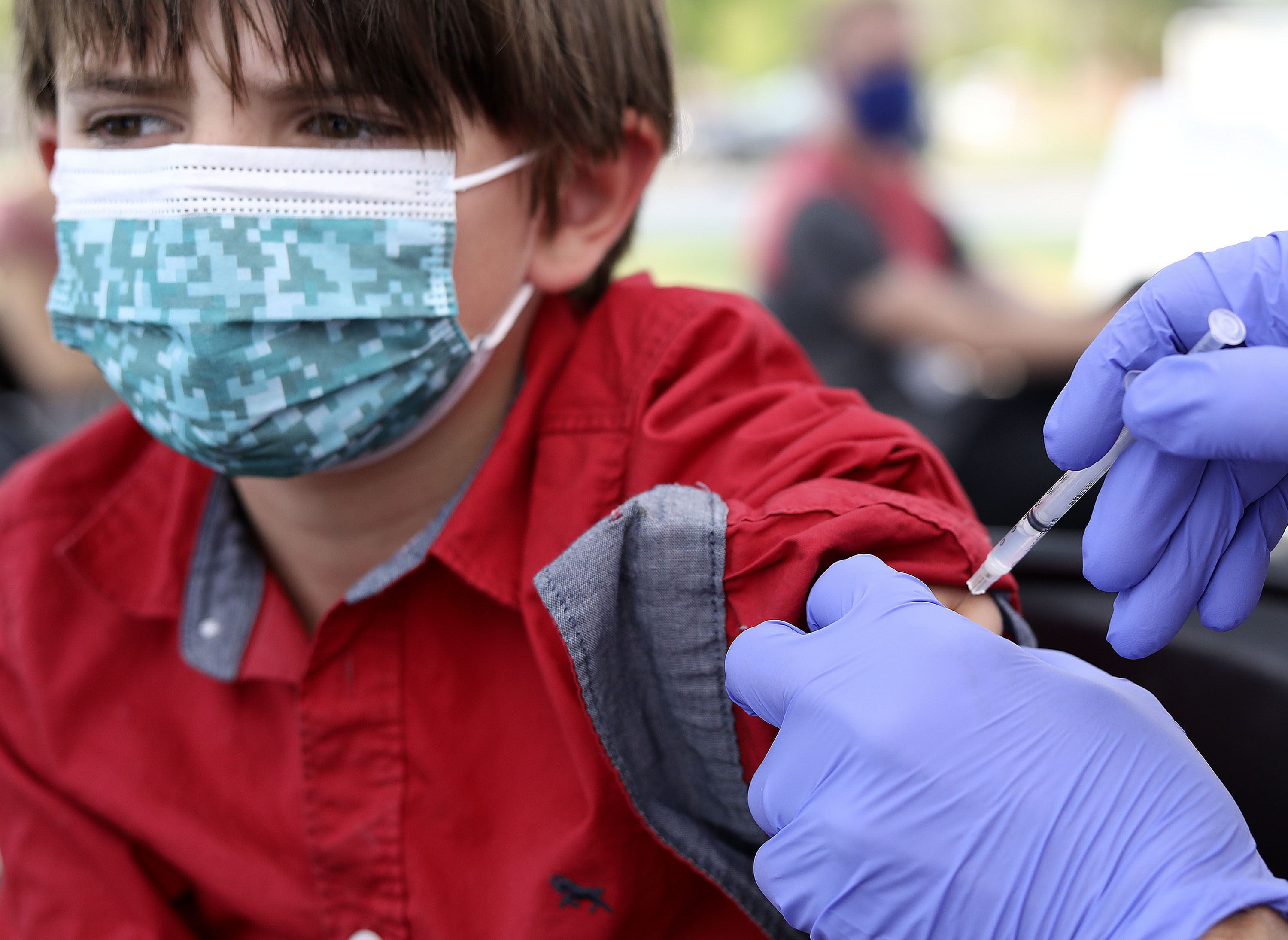 Asher Williams, 12, of Salt Lake City, gets a COVID-19 vaccination at Rose Park Elementary in Salt Lake City on Wednesday. As Utah sees a slightly lower average case count this week compared to last, one doctor said Friday it could be a sign the state is on a downward trend like some other national hot spots of the disease.