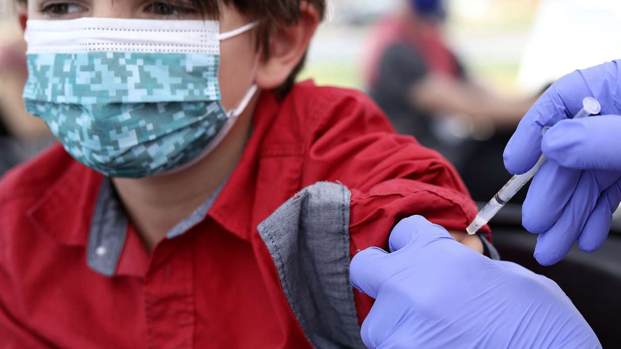 Asher Williams, 12, of Salt Lake City, gets a COVID-19 vaccination at Rose Park Elementary in Salt Lake City on Wednesday.