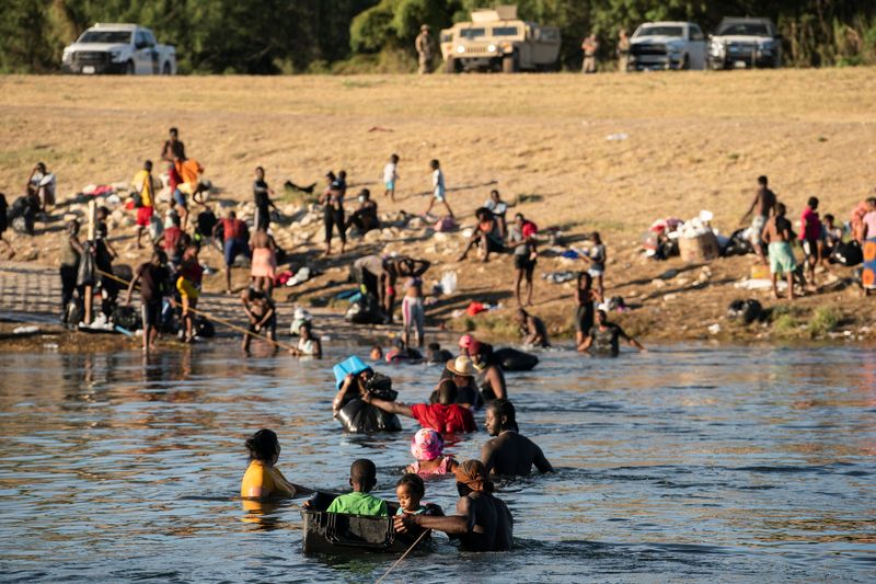 Migrants seeking asylum in the U.S. cross the Rio Grande river near Ciudad Acuna, Mexico, Tuesday. The U.S. special envoy to Haiti dramatically resigned on Thursday.