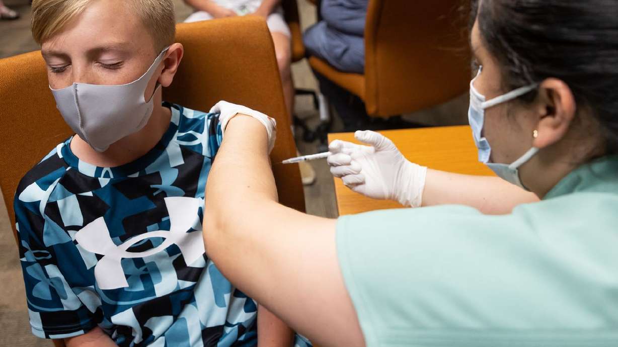 Jack Allen, 12, closes his eyes as he gets a shot of the Pfizer-BioNTech COVID-19 vaccine from nurse Estefania Cruz at
the Central Davis Senior Activity Center in Kaysville on July 6, 2021. Children as young as 5 years old may be able to be
vaccinated against COVID-19 by Halloween.