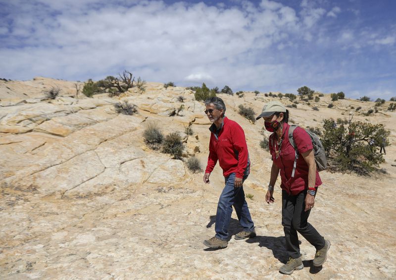 Gary Torres, Bureau of Land Management district manager
for southeast Utah, left, and Interior Secretary Deb Haaland hike
to the Butler Wash Ruins in Bears Ears National Monument in San
Juan County on April 8.