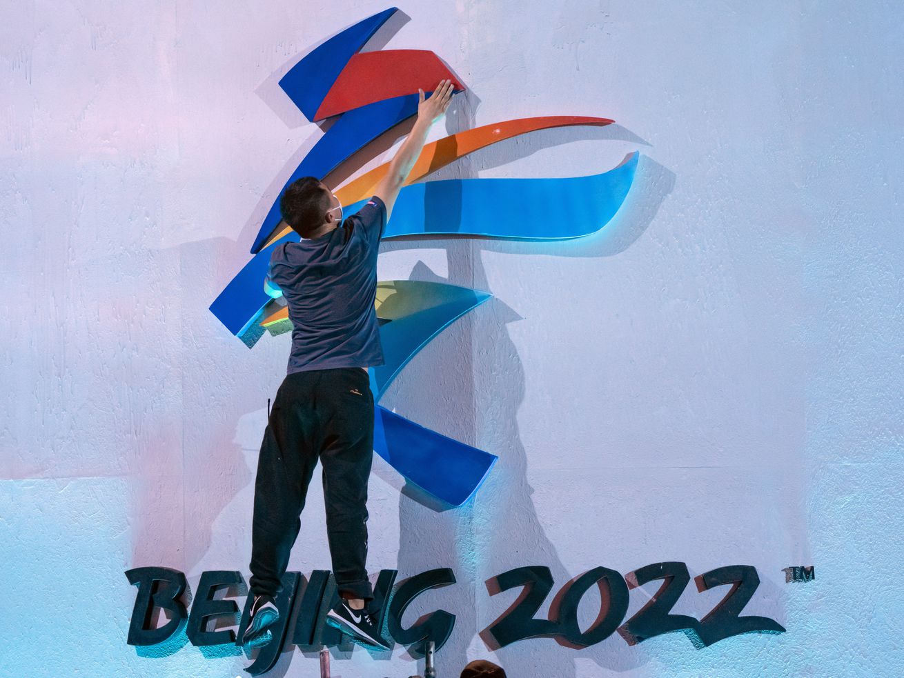 A crew member leaps to fix a logo for the 2022 Beijing Winter Olympics in Beijing on Sept. 17, before a launch ceremony to reveal the motto for the Winter Olympics and Paralympics. U.S. Olympic officials don’t seem to be in any rush to decide whether Salt Lake City is bidding for the 2030 or 2034 Winter Games.