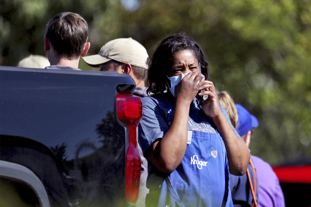 A Kroger employee talks on a cellphone following a shooting at a Kroger's grocery store in Collierville, Tenn., on Thursday.