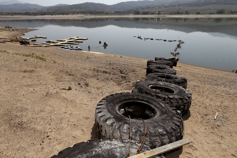 Tires used to break waves from watercraft are seen on
the beach due to low water levels at Pineview Reservoir near
Huntsville, Weber County, on Sept. 9. When the
tires were positioned in mid-July, only three could be seen on the
beach. Fourteen tires are visible now.