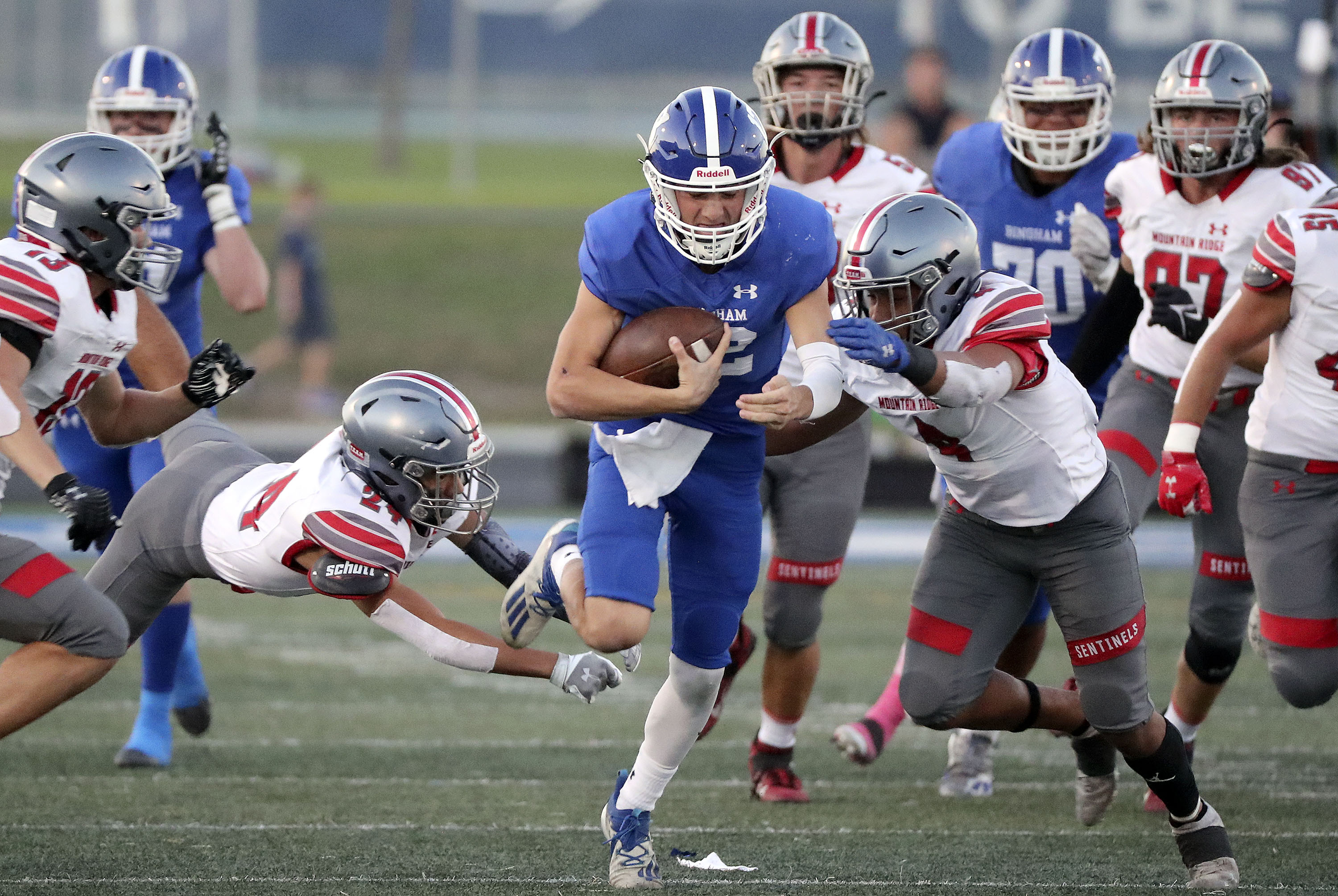 Bingham’s Dallen Martinez gets tackled by Mountain Ridge’s Chase Leiataua (24) and DeMarco Brimmage (4) during a high school football game at Bingham High School in South Jordan on Friday, Sept. 24, 2021. Bingham won 45-14.
