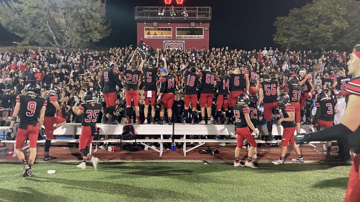 Weber football players celebrate with the student section after winning the homecoming game 24-20