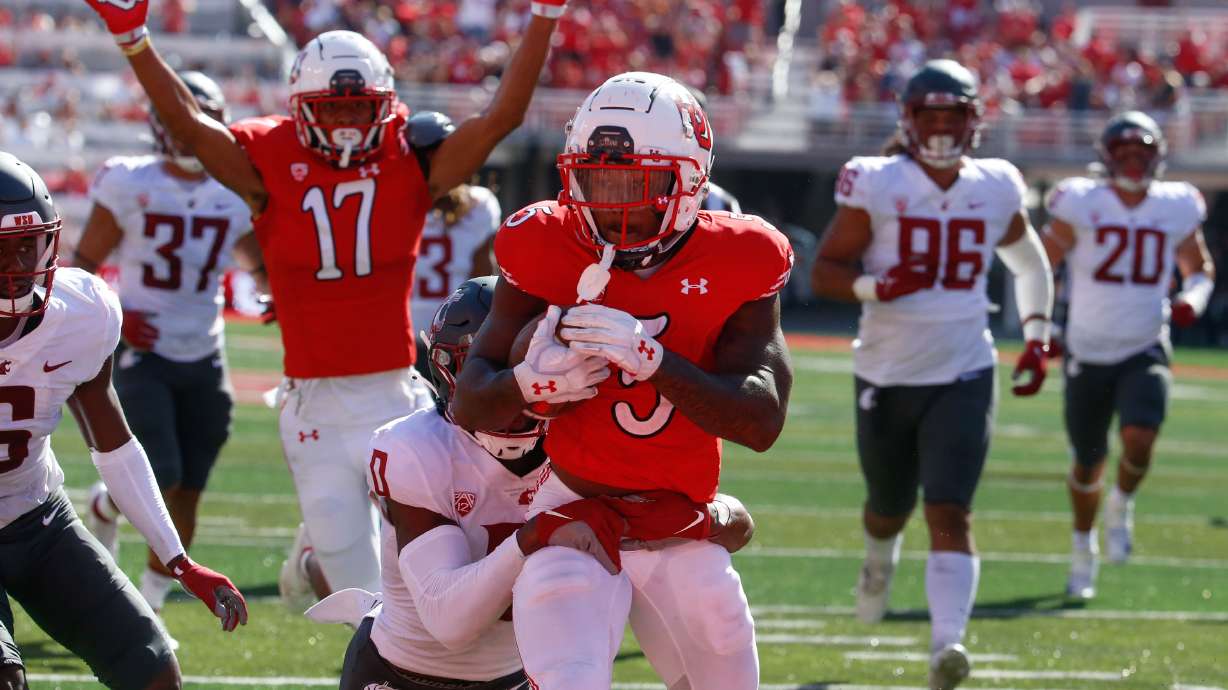Utah running back TJ Pledger, center, gets tackled by Washington State defensive back Jaylen Watson as others celebrates during touchdown of an NCAA college football game at Rice-Eccles Stadium on Saturday, Sept. 25, 2021 in Salt Lake City. Utah won the game 24-13.