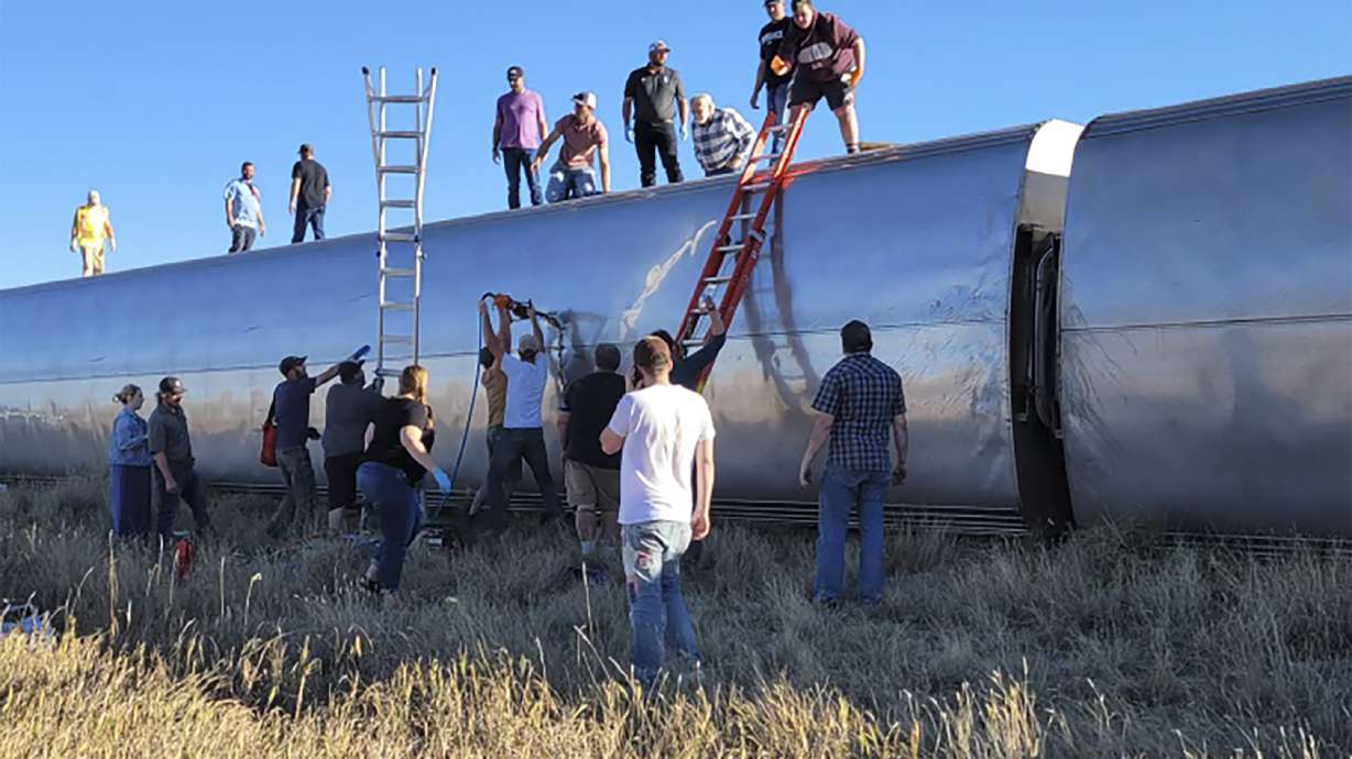 In this photo provided by Kimberly Fossen people work at the scene of an Amtrak train derailment on Saturday, in north-central Montana. Multiple people were injured when the train that runs between Seattle and Chicago derailed Saturday, the train agency said.