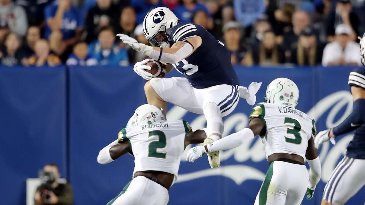 Brigham Young Cougars fullback Masen Wake (13) tries to hurdle South Florida Bulls defensive back TJ Robinson (2) on a run as BYU and USF play a college football game at LaVell Edwards Stadium in Provo on Saturday, Sept. 25, 2021.