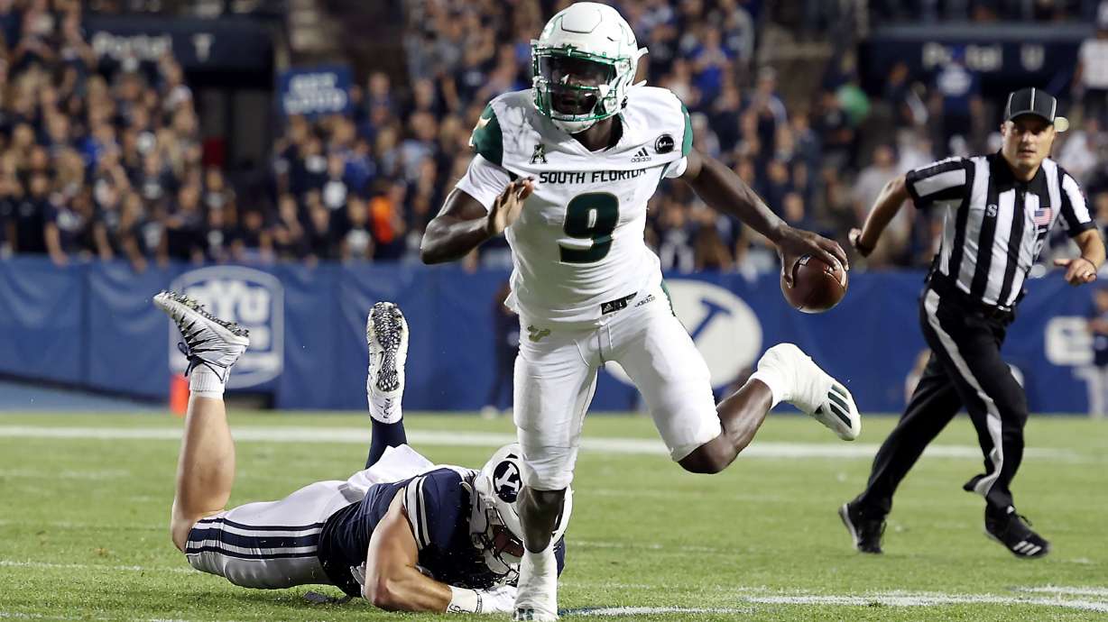 South Florida Bulls quarterback Timmy McClain (9) runs away from Brigham Young Cougars defensive lineman Fisher Jackson (53) as BYU and USF play a college football game at LaVell Edwards Stadium in Provo on Saturday, Sept. 25, 2021. BYU won 35-27.