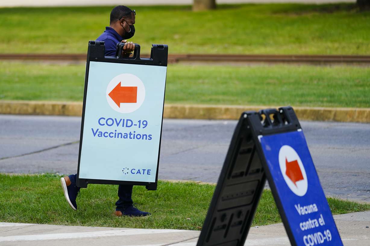 A worker posts placard for a COVID-19 vaccination clinic at the Reading Area Community College in Reading, Pa.