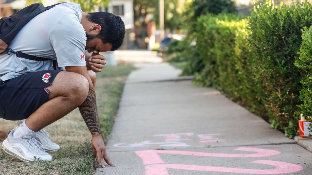 Samuelu Elisaia, former University of Utah football player and teammate of sophomore defensive back Aaron Lowe closes his eyes as he pays respect in front of a makeshift memorial at the incident of shooting on Sunday, Sept. 26, 2021 in Salt Lake City’s Sugar House neighborhood.