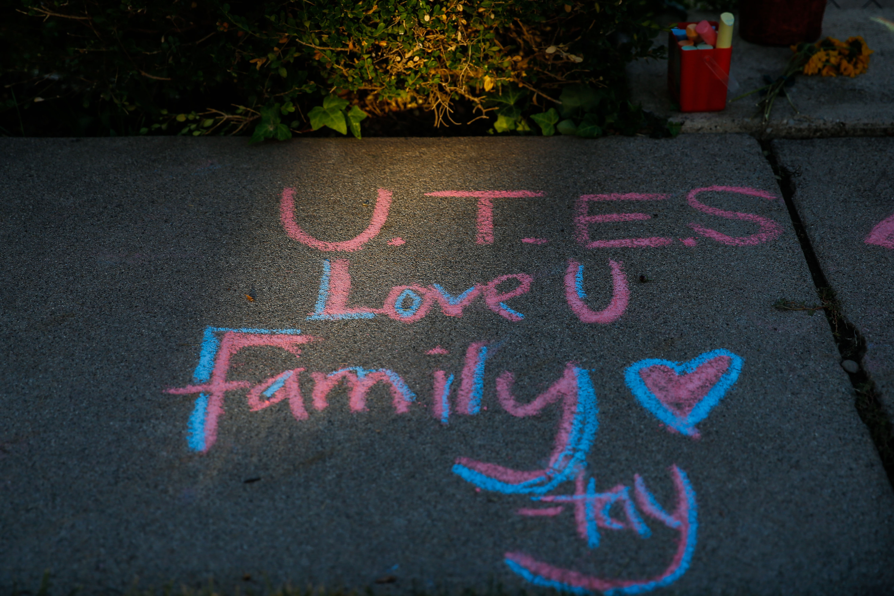 The evening light falls on the words written on the sidewalk in memory of University of Utah sophomore and football defensive back Aaron Lowe, Sunday, Sept. 26, 2021 in Salt Lake City’s Sugar House neighborhood. Lowe was shot and killed early Sunday morning during a house party.