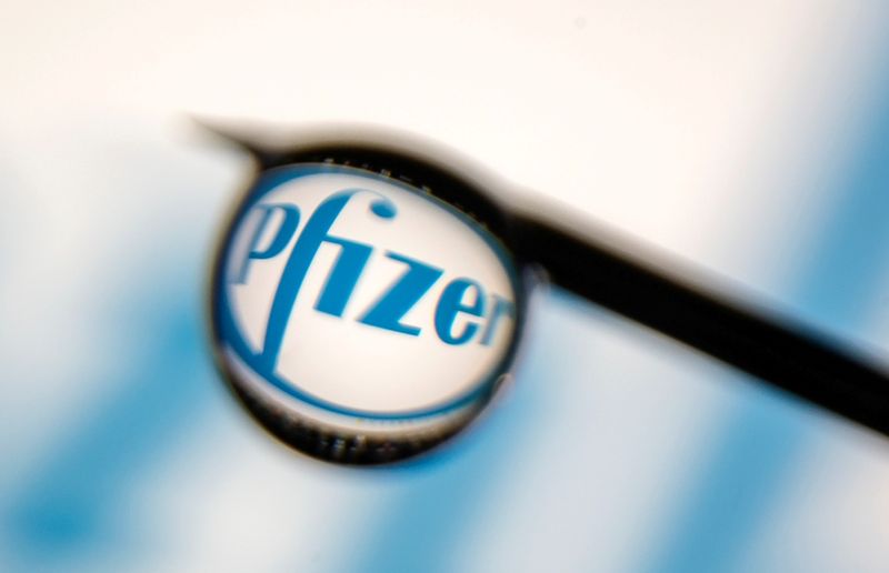 The Pfizer logo is reflected in a drop on a syringe needle in this illustration photo. Pfizer said on Monday it has started a large study testing its investigational oral antiviral drug for the prevention of COVID-19 infection.