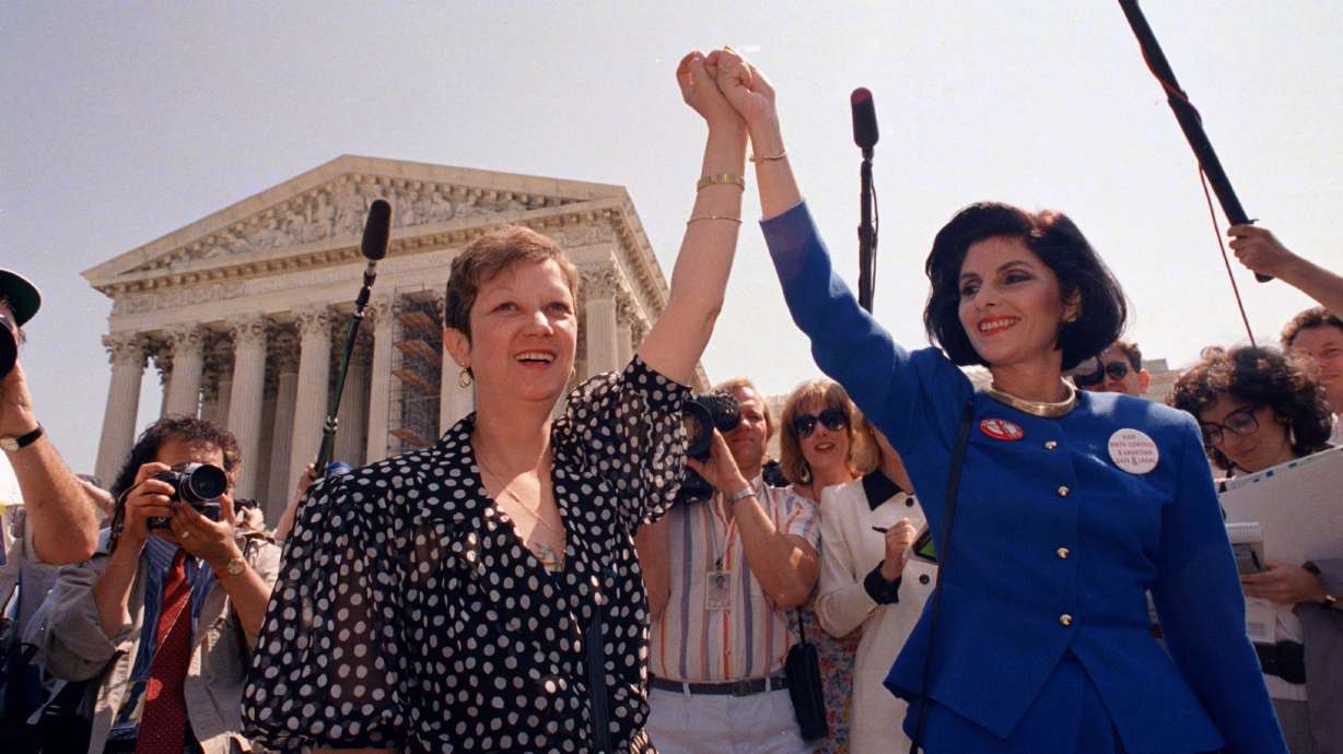 In this April 26, 1989 photo, Norma McCorvey, Jane Roe in the 1973 court case, left, and her attorney Gloria Allred hold hands as they leave the Supreme Court building in Washington. The revelations McCorvey offered in the 2020 documentary “AKA Jane Roe” made nationwide headlines but stand little chance of denting anti-abortion activists’ momentum with a president who has proudly embraced their goals.