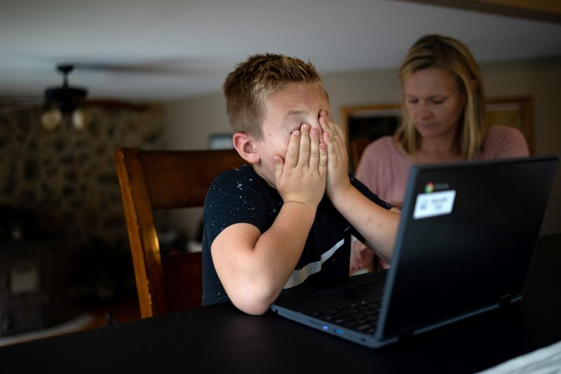Kelly Toth helps her son, Alex Toth, 7, with his homework at their home in Schnecksville, P.A., on Sept. 22.