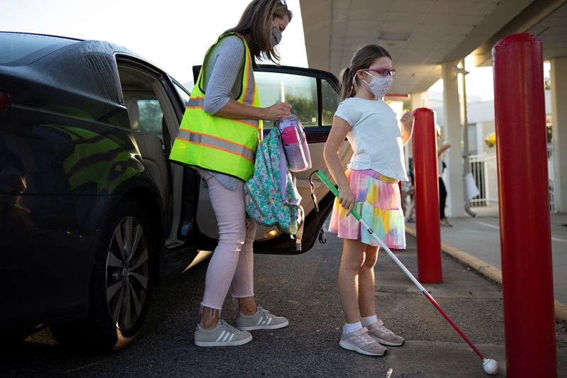 Ella Rose Corley, 8, who contracted an infection in her early childhood which left her legally blind, is helped out of a car before heading into school in Vestavia Hills, Ala., on Monday.