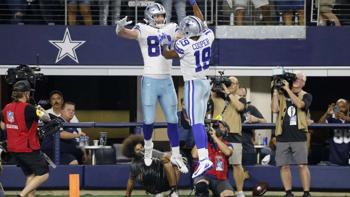 Dallas Cowboys tight end Dalton Schultz (86) and wide receiver Amari Cooper (19) celebrate a touchdown catch made by Schultz in the first half of an NFL football game against the Philadelphia Eagles in Arlington, Texas, Monday, Sept. 27, 2021.