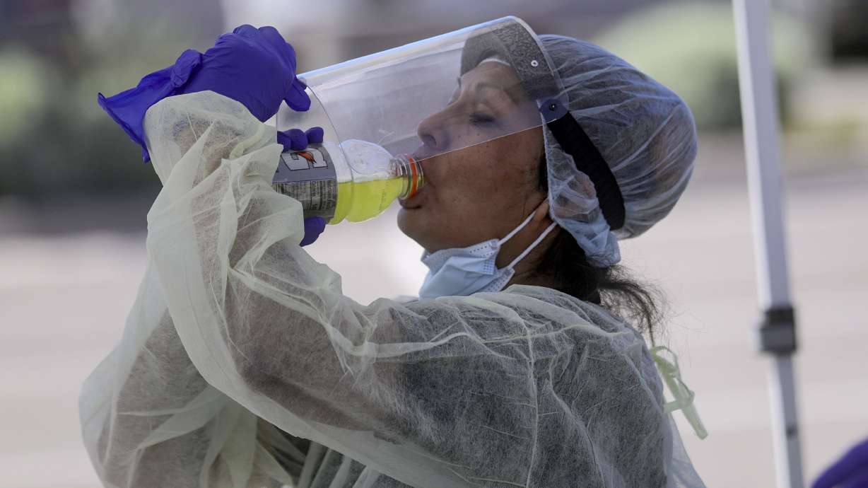 Bonnieva Bitsuie, Utah Navajo Health System contracted maintenance worker and housekeeper, lifts her face shield to take a sip of Gatorade while working with a mobile COVID-19 testing unit outside of the Montezuma Creek Community Health Center in Montezuma Creek, San Juan County, on May 1, 2020. Utah Navajo Health System is one of 11 Utah health centers to receive funding from the American Rescue Plan Act.