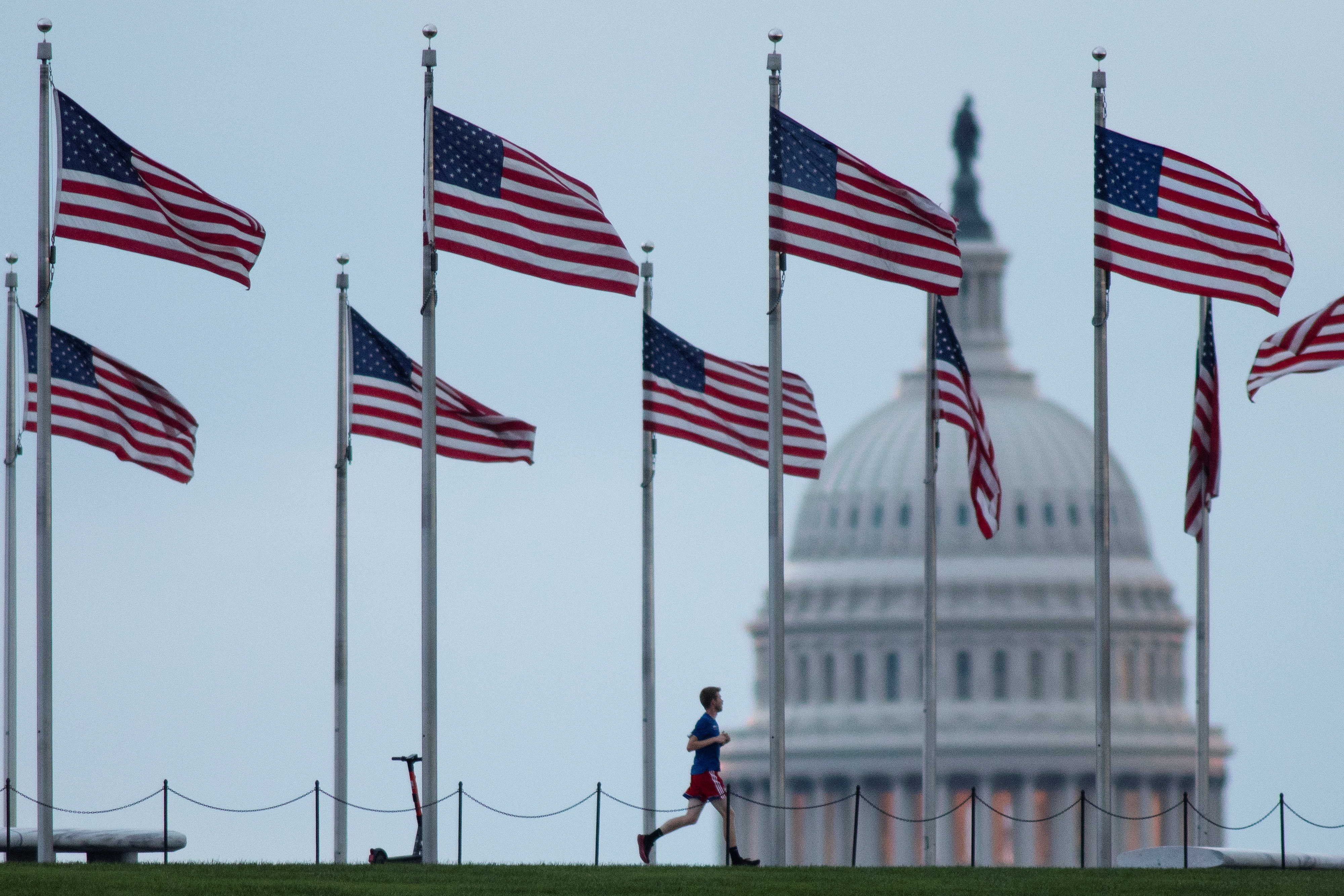 A visitor runs around the Washington Monument near the U.S. Capitol at dawn, in Washington, D.C., on Wednesday. Congress on Wednesday had just two days left before the federal government begins shutting many of its operations unless Democrats manage to pass a bill providing new funding for the fiscal year that begins on Friday.