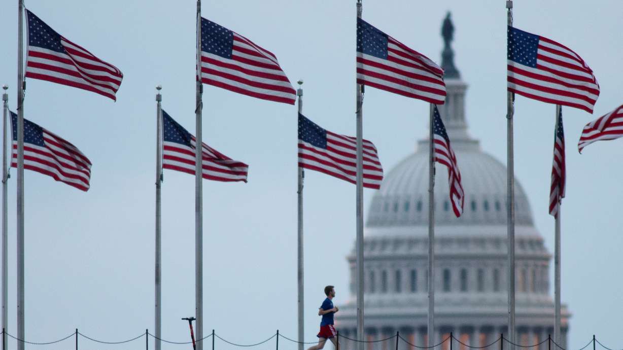 A visitor runs around the Washington Monument near the U.S. Capitol at dawn, in Washington, D.C., on Wednesday. Congress on Wednesday had just two days left before the federal government begins shutting many of its operations unless Democrats manage to pass a bill providing new funding for the fiscal year that begins on Friday.