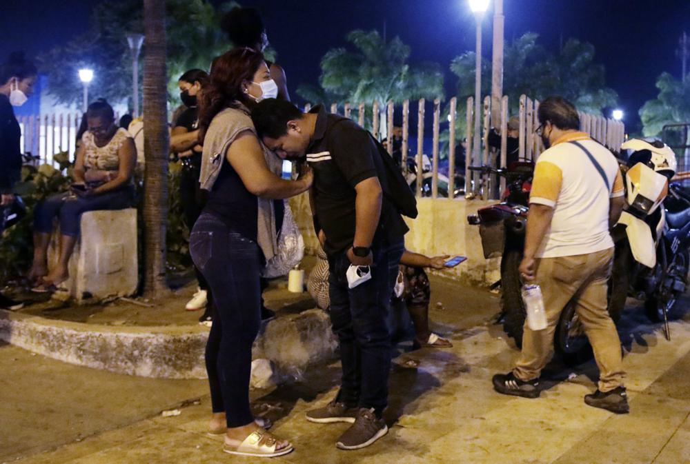 A woman comforts a man outside the morgue while waiting for the bodies of inmates killed in a riot at the Litoral penitentiary in Guayaquil, Ecuador, on Wednesday. President Guillermo Lasso said in a press conference that the dead are so far 116.