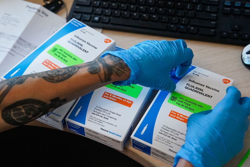 Nurse Kimberly Goldberg puts labels on boxes with
influenza vaccine at the Salt Lake Public Health Center on
Thursday.