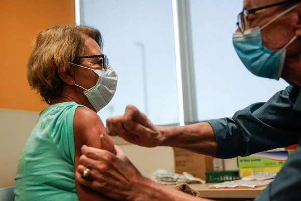 Minka Tasevac receives a Pfizer-BioNTech COVID-19
vaccine from by nurse Jon Hight at the Salt Lake Public Health
Center on Thursday.