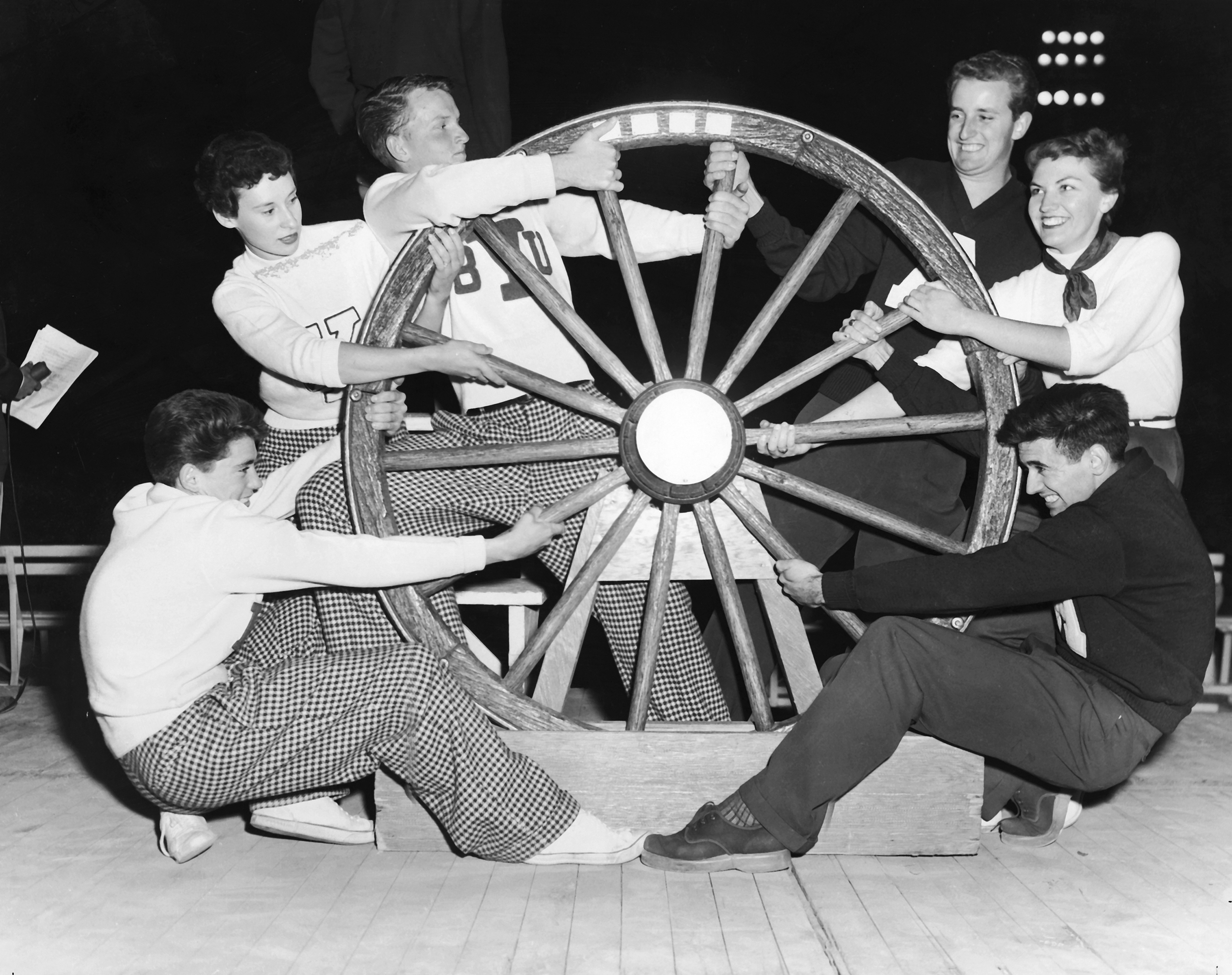 BYU and Utah State students pull on the Old Wagon Wheel before a football game between the two schools in 1953.