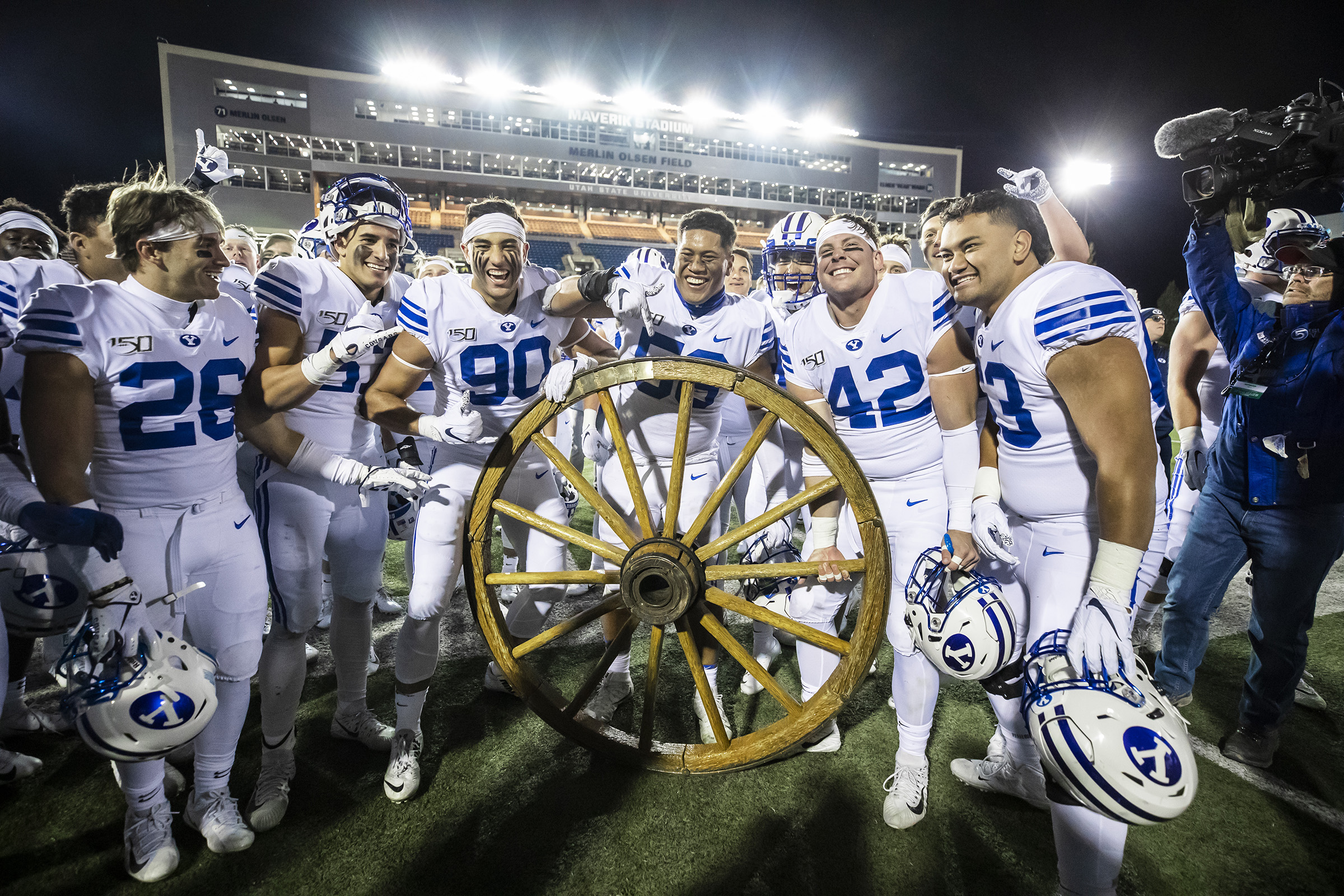 BYU players pose with the Old Wagon Wheel following a 42-14 win over in-state rival Utah State in 2019 in Logan.