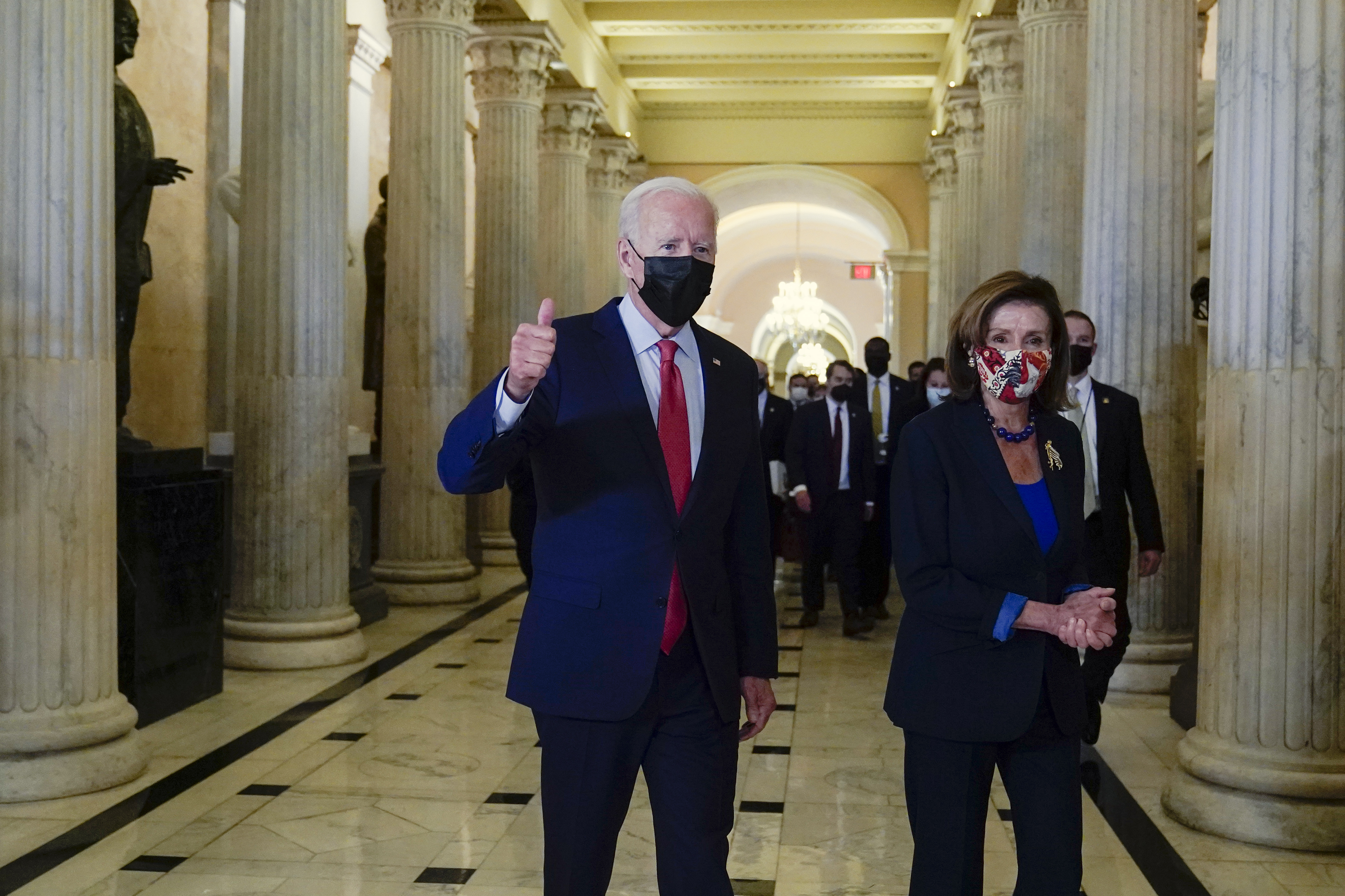 President Joe Biden gives a thumbs-up as he walks with House Speaker Nancy Pelosi of California, on Capitol Hill in Washington on Friday after attending a meeting with the House Democratic caucus to try to resolve an impasse around the bipartisan infrastructure bill.
