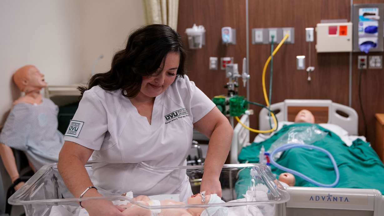 Dominique Elder, a student and respiratory therapist assistant at Utah Valley University, prepares a mannequin to practice nasal continuous positive airway pressure therapy during a lab at the Orem university on Thursday.