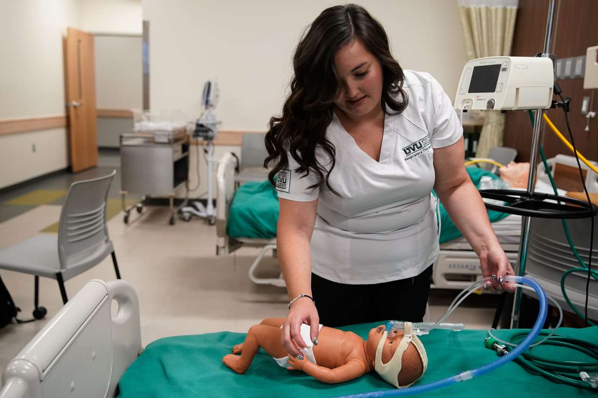 Dominique Elder, a student and respiratory therapist assistant at Utah Valley University, practices neonatal continuous positive airway pressure therapy on a mannequin during a lab session at the Orem university on Thursday.