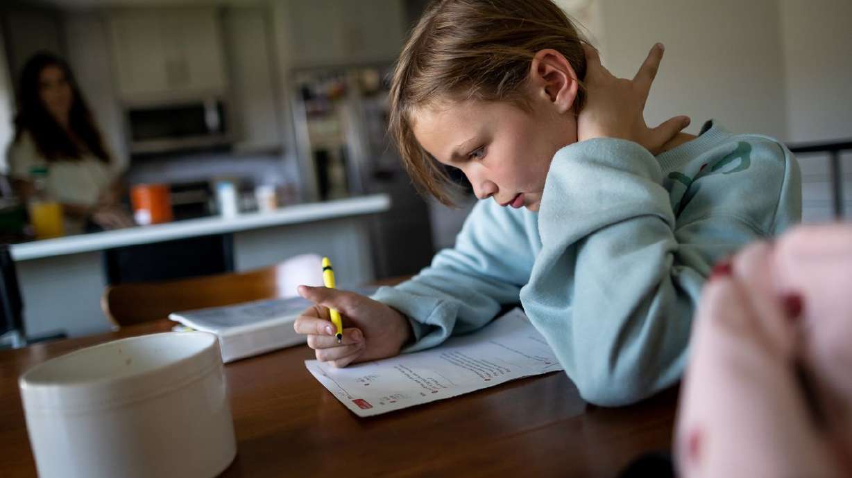 Emery Blackburn, 9, does her homework after returning from school at her home in South Jordan on Sept. 14. Emery and her mother, Ashley, have both experienced long-haul symptoms since the family had COVID-19 in July 2020.