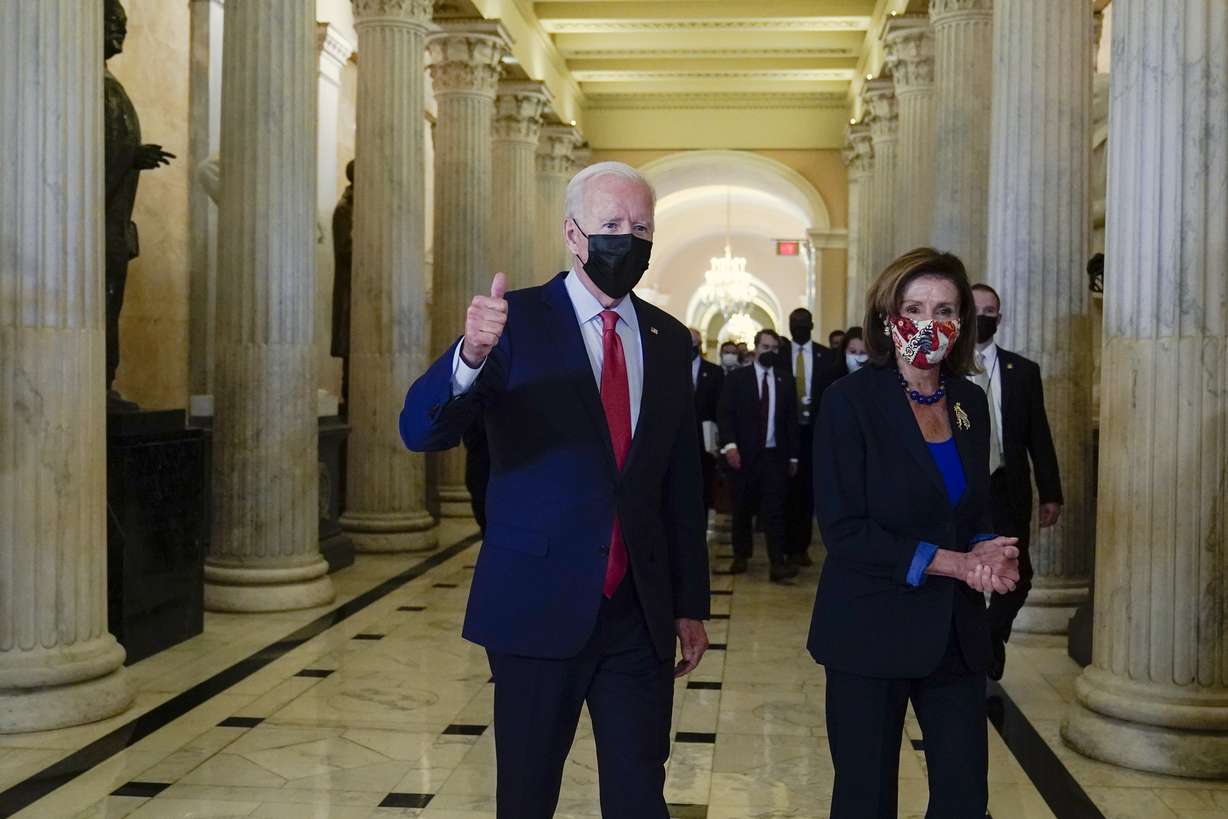 President Joe Biden gives a thumbs up as he walks with House Speaker Nancy Pelosi of Calif., on Capitol Hill in Washington, Friday, after attending a meeting with the House Democratic caucus to try to resolve an impasse around the bipartisan infrastructure bill.
