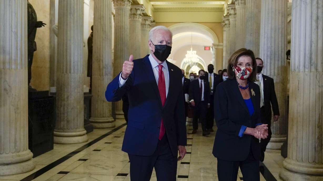 President Joe Biden gives a thumbs-up as he walks with House Speaker Nancy Pelosi of Calif., on Capitol Hill in Washington, Friday after attending a meeting with the House Democratic caucus to try to resolve an impasse around the bipartisan infrastructure bill.