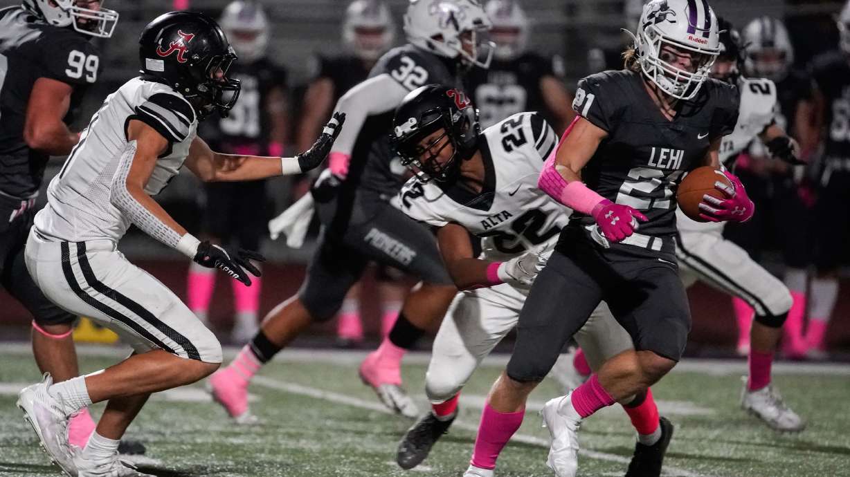 Lehi’s Kadiyon Sweat (21) runs past Alta’s Jalen Sutton during a high school football game at Lehi High School in Lehi on Friday, Oct. 1, 2021.