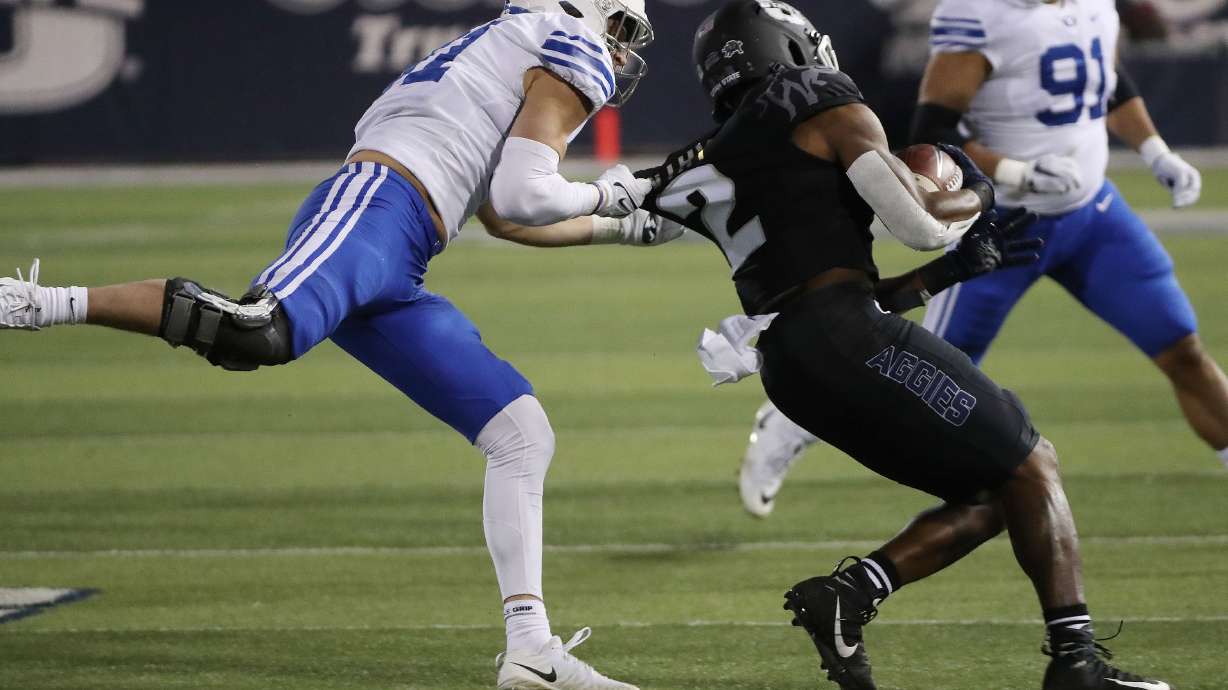Brigham Young Cougars linebacker Max Tooley (31) tackles Utah State Aggies running back John Gentry (2) in Logan on Friday, Oct. 1, 2021.