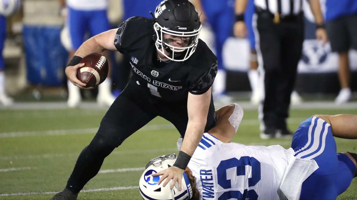 Utah State Aggies quarterback Logan Bonner (1) runs against Brigham Young Cougars linebacker Ben Bywater (33) in Logan on Friday, Oct. 1, 2021.