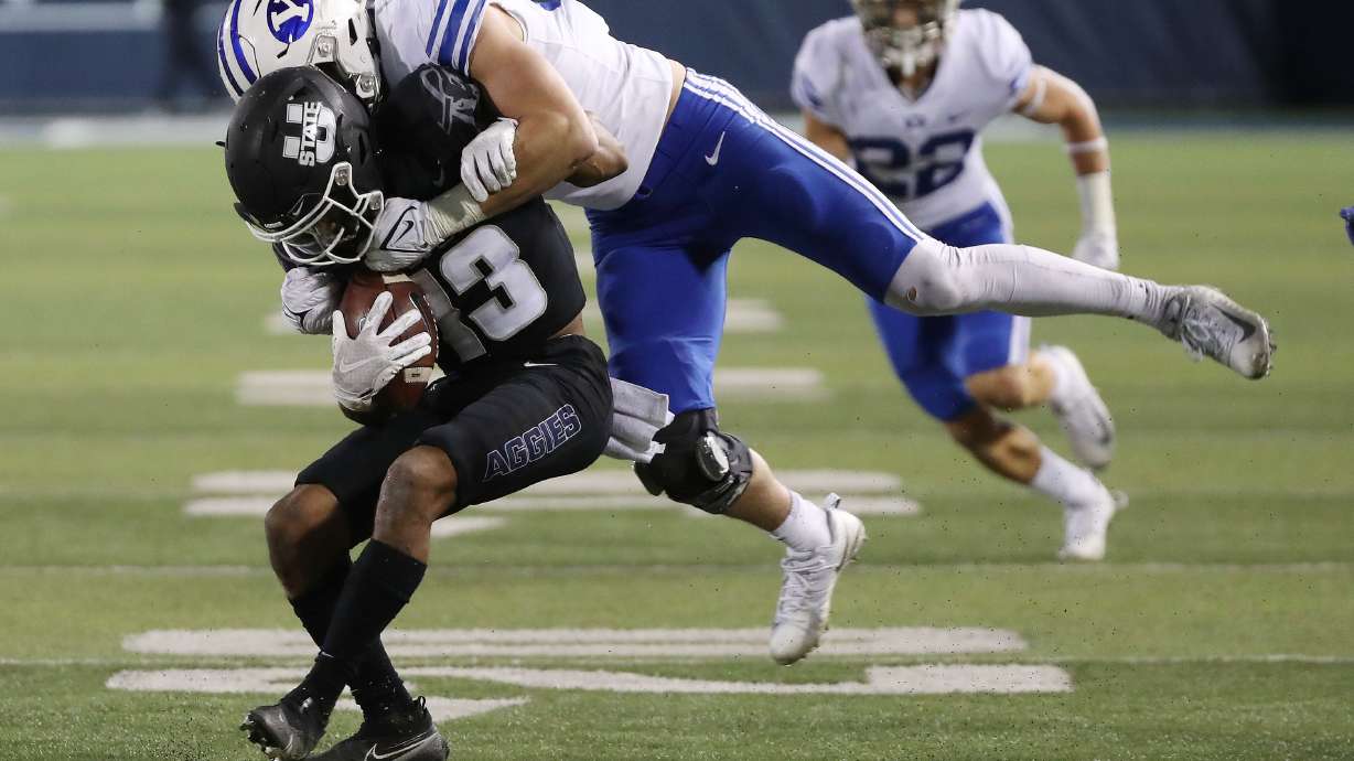 Brigham Young Cougars linebacker Max Tooley (31) tackles Utah State Aggies wide receiver Deven Thompkins (13) in Logan on Friday, Oct. 1, 2021.