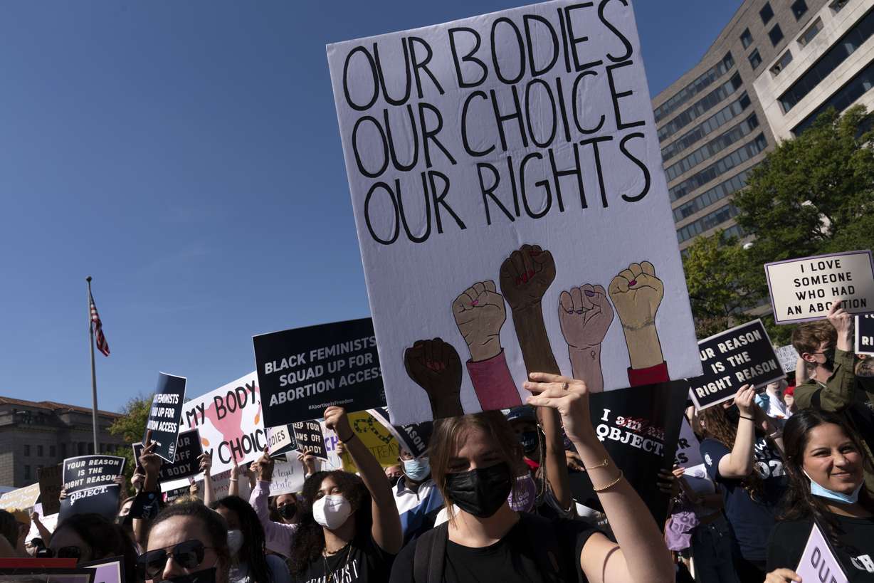 Activists hold signs during the Women's March rally at Freedom Plaza, in Washington, Saturday.