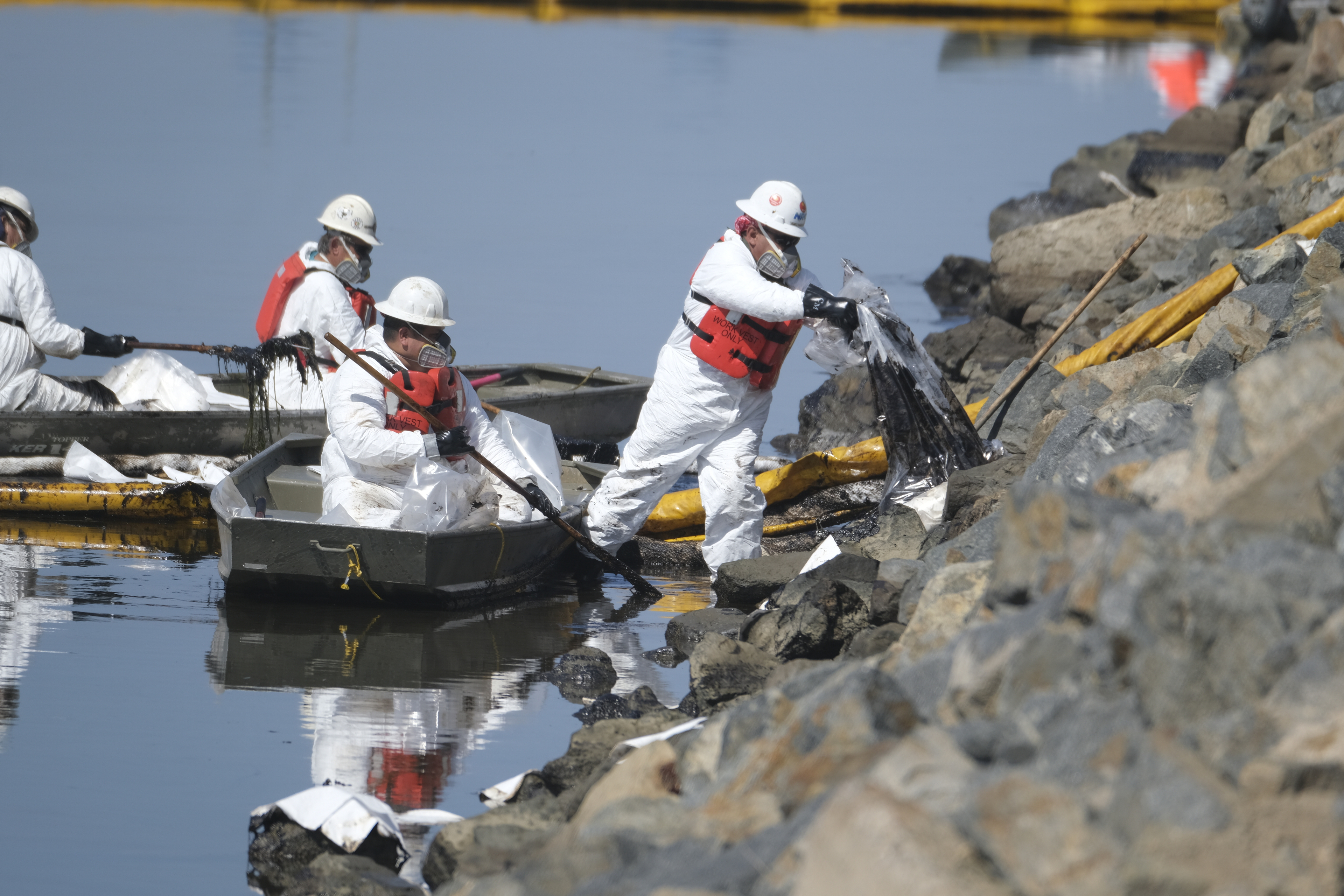 Cleanup contractors unload collected oil in plastic bags trying to stop further oil crude incursion into the Wetlands Talbert Marsh in Huntington Beach, Calif., Sunday. One of the largest oil spills in recent Southern California history fouled popular beaches and killed wildlife while crews scrambled Sunday to contain the crude before it spread further into protected wetlands.