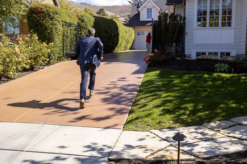 Rep. Blake Moore, R-Utah, runs up a driveway for the start of a fundraising event for his campaign in Salt Lake City on Monday. Moore invited Rep. Liz Cheney, R-Wyo., to the event, but an apparent flight delay kept her from
attending.